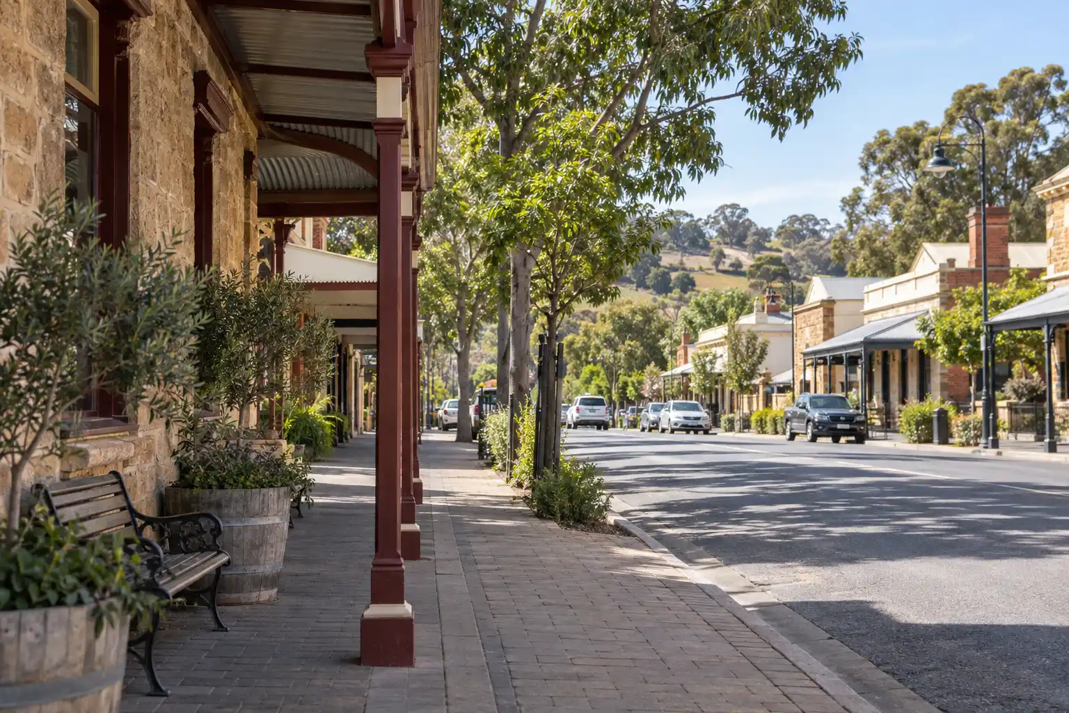 Tree-lined country street with stone hotel buildings